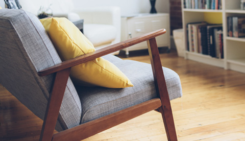 Grå fåtölj med gul kudde